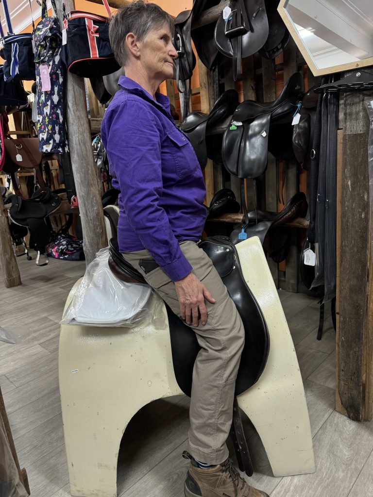 Horse rider trying a saddle by sitting on a Saddle Tree